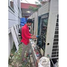 Technician checking the control wiring in outdoor HVAC equipment